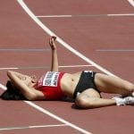 Fadwa Sidi Madane of Morocco lies exhausted the women’s 3,000 metres steeplechase heat during the 15th IAAF World Championships at the National Stadium in Beijing