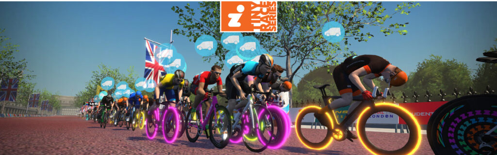 Cyclists race closely together on a road with glowing, colorful wheels in a virtual cycling event. British flags and speech bubbles with thumbs-up icons appear in the background under a Zwift logo.