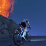 A cyclist rides uphill at night near a rocky slope with a bright, fiery explosion or eruption lighting up the sky in the background.