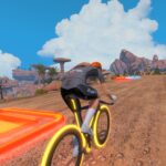 A cyclist in a black outfit rides a glowing yellow bike up a dirt road in a rocky, virtual landscape with colorful neon strips on the ground and bright blue skies overhead.