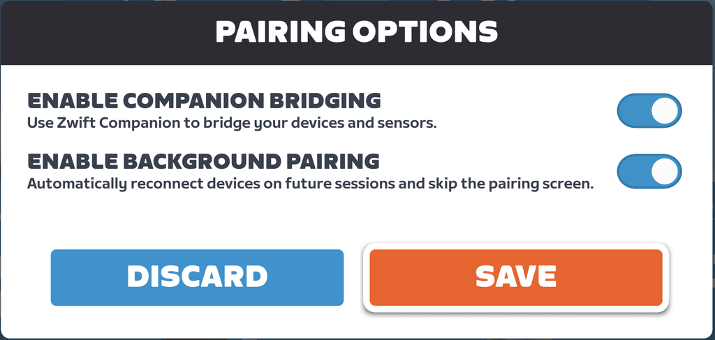 Zwift pairing options screen with toggles for Enable Companion Bridging and Enable Background Pairing, both turned on. Two buttons at the bottom read Discard in blue and Save in orange.