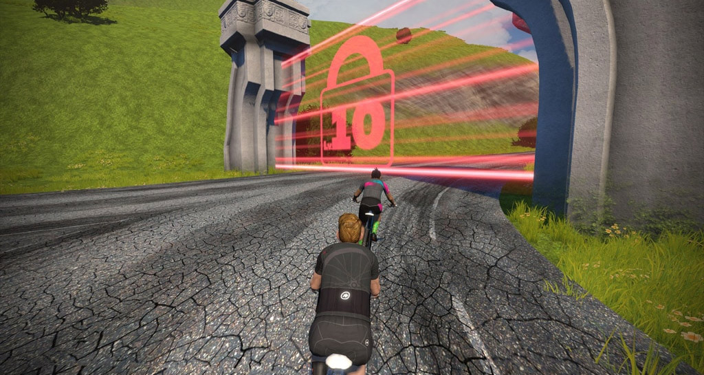 Two cyclists approach a virtual red gate with a large locked padlock icon, blocking the road in a digital landscape with green hills and cracked pavement.