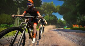 Two cyclists riding mountain bikes along a dirt path through a forest.